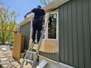 Installer working on window replacement (exterior view)