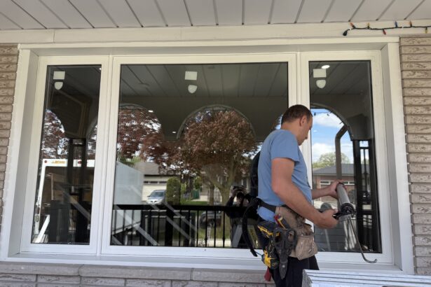 Installer sealing and finishing a replacement window during a window installation project in Barrie.